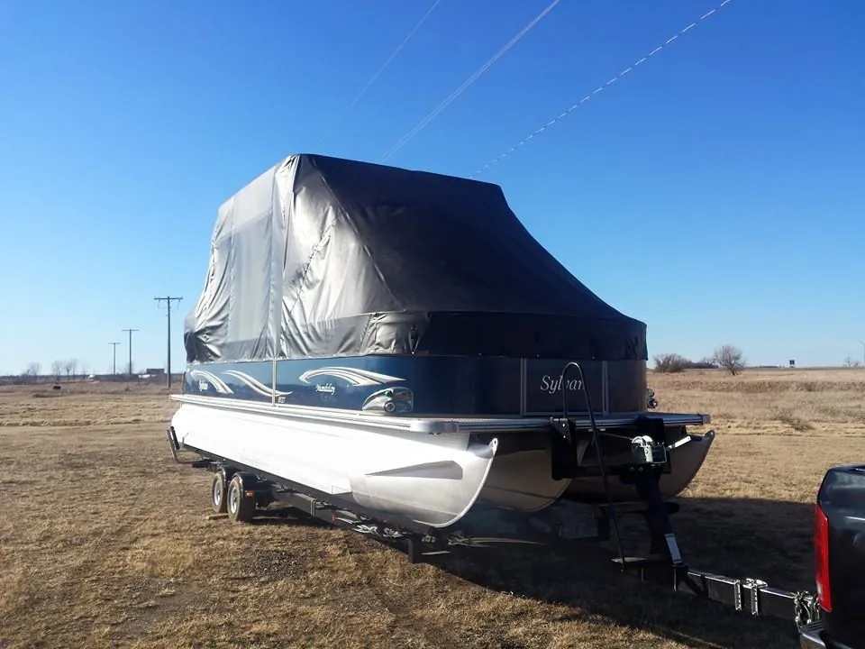 Pontoon boat on a trailer under a black custom pontoon cover