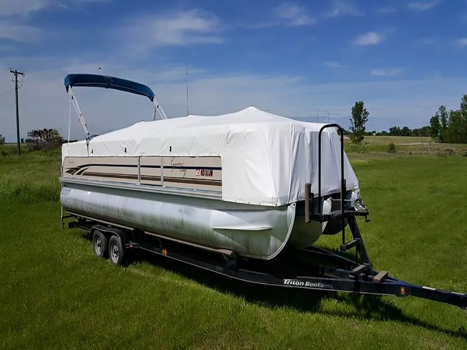 Pontoon boat on a trailer under a white custom pontoon cover