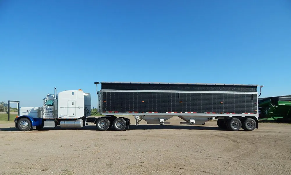 Semi truck with a hopper grain trailer fitted with a Hi-Rizer extension