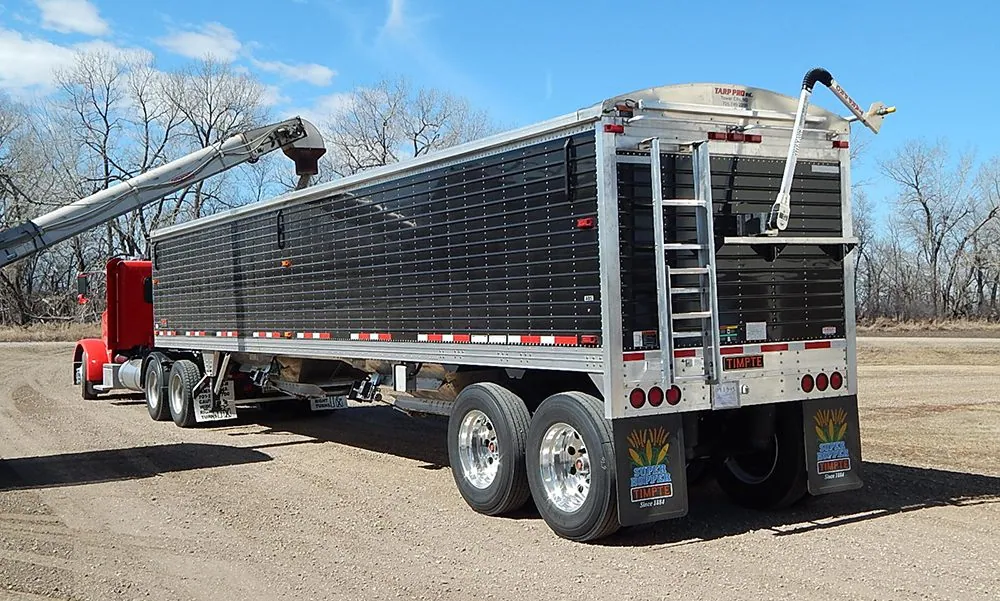 Grain trailer with an electric roll tarp kit, tarp arm raised