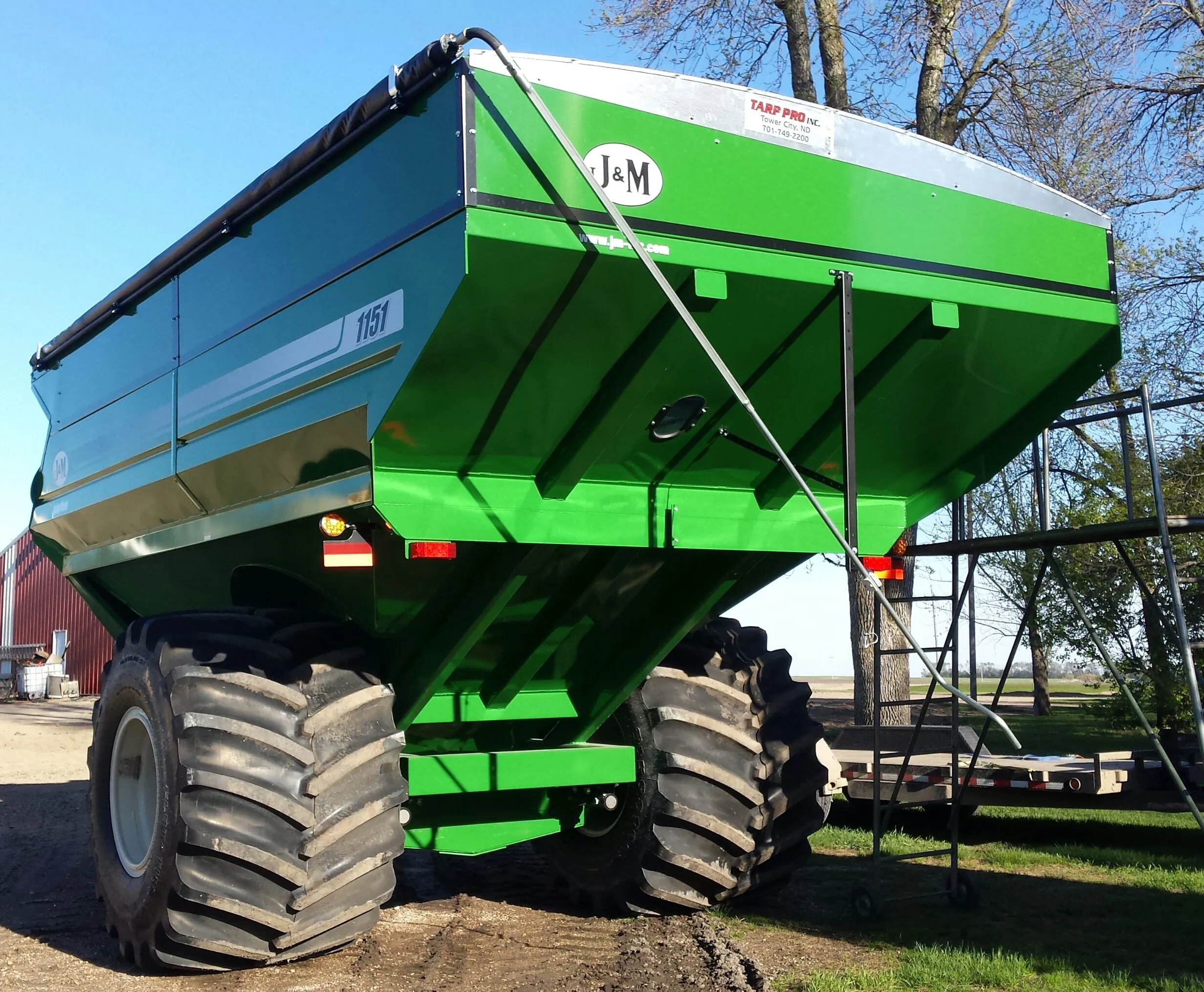 Green J&M grain cart with a roll tarp kit
