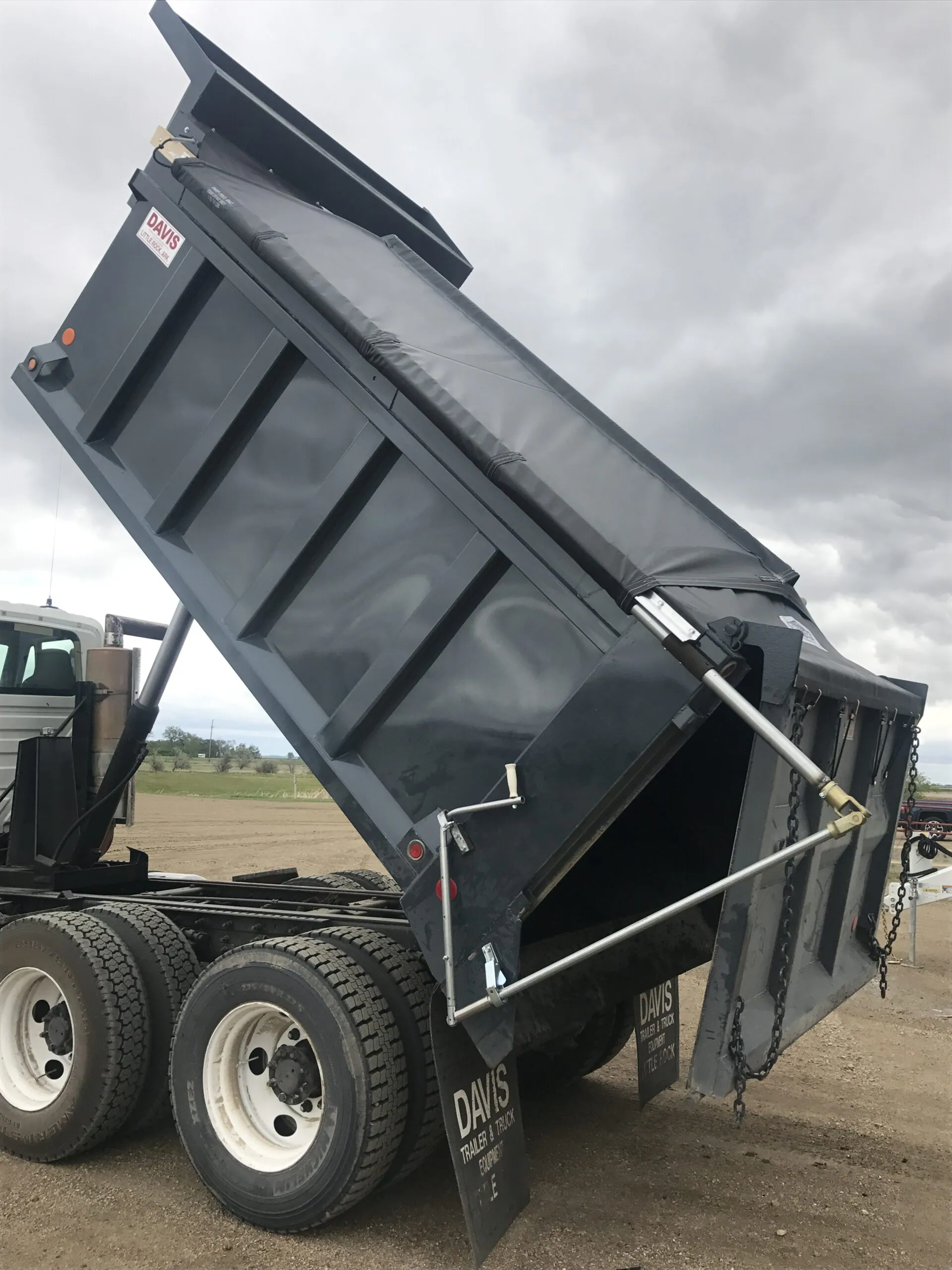 Side dump trailer raised, fitted with an IronSide2 electric roll tarp