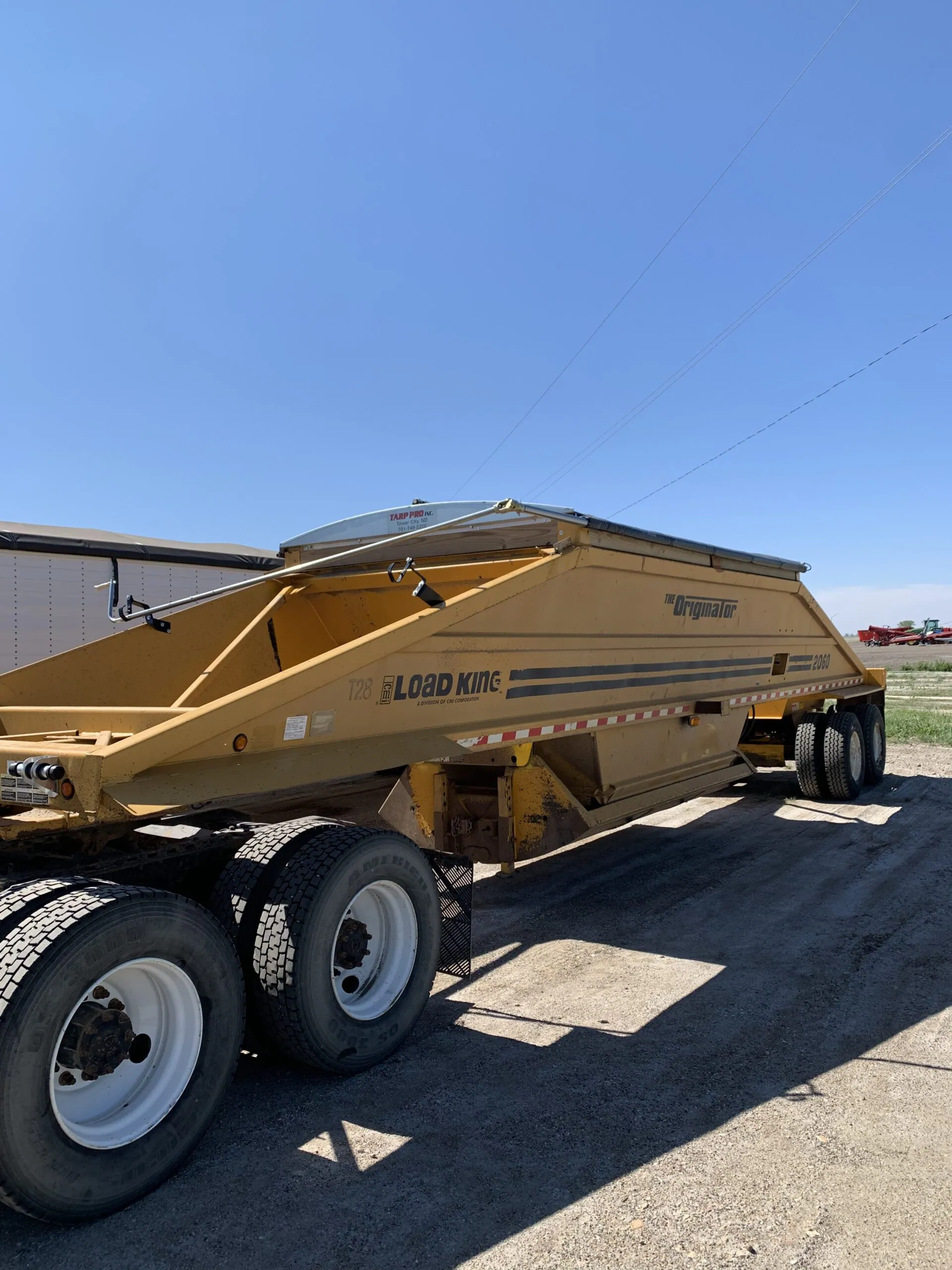 Belly dump trailer with an electric roll tarp