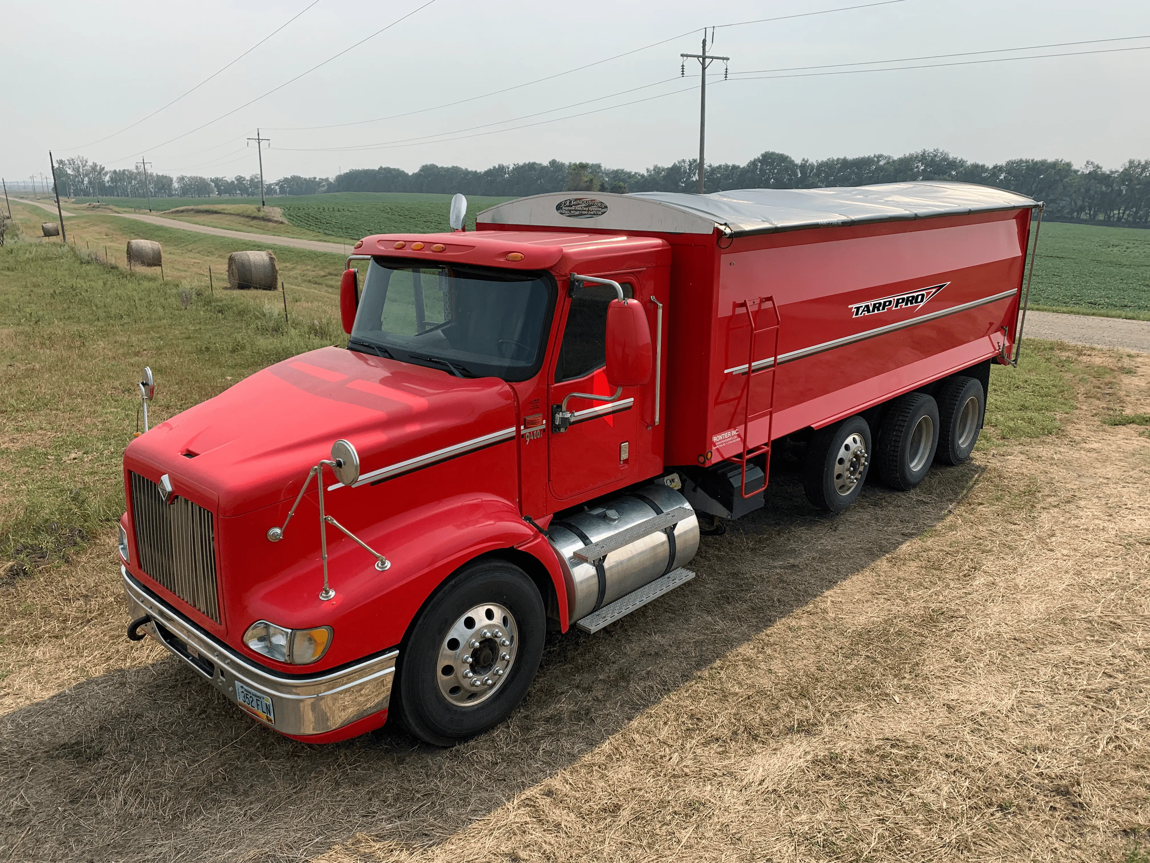 Red grain truck with a roll tarp kit on the box